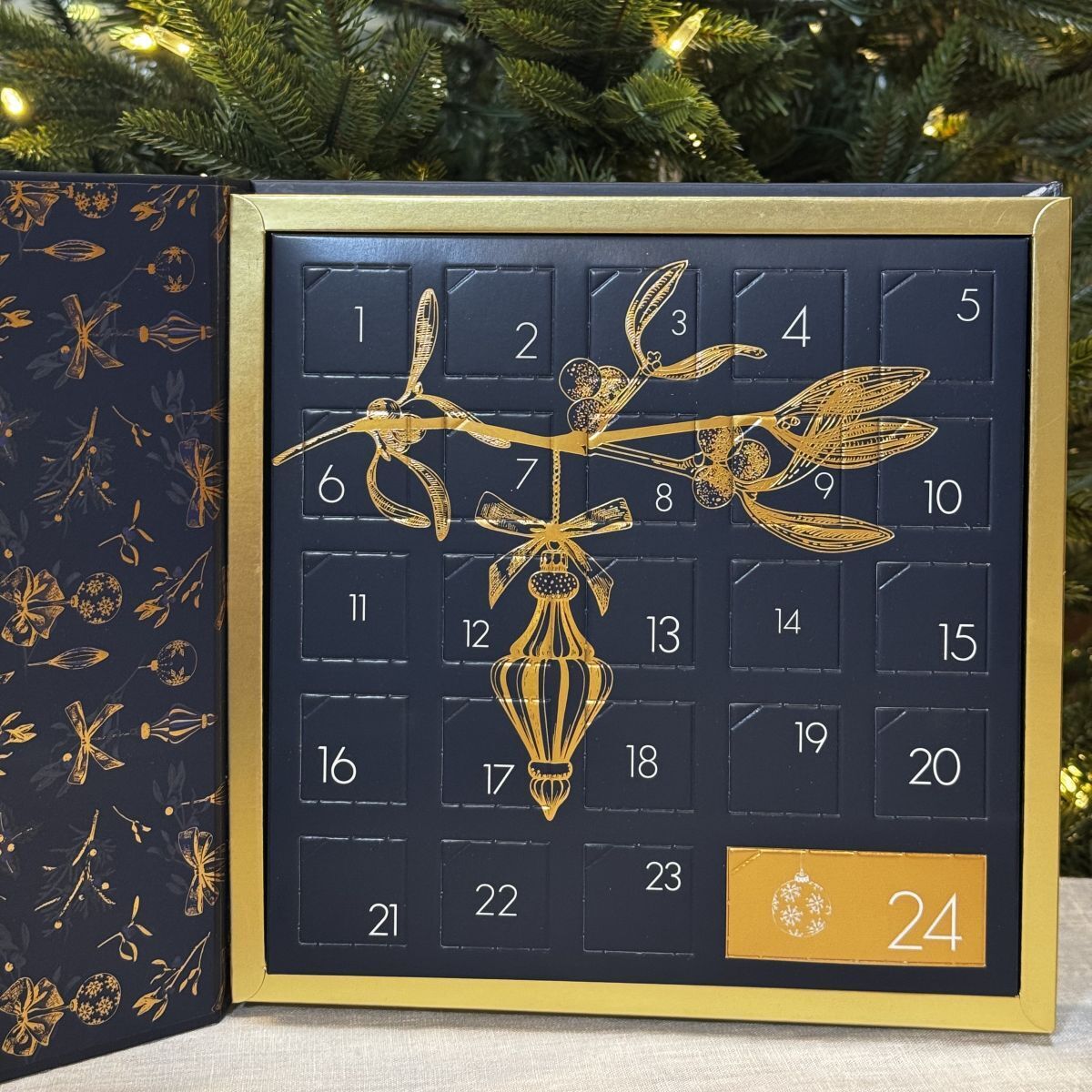 calendrier de l’Avent bleu marine et or de 24 cases. Dans chaque case un chocolat maison artisanal