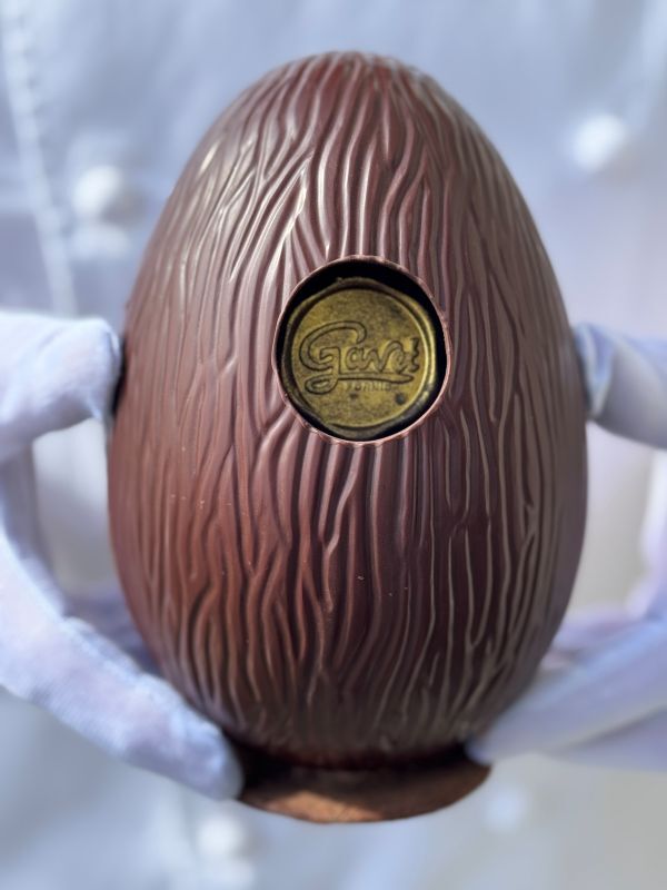 Chocolat artisanal aux formes uniques, oeuf en chocolat noir à partir d'un chocolat unique aux origines de Saint Domingue et du Pérou. Cetoeuf est garni d'un oeuf tout chocolat, d'oeufs oraliné noir et de fritures chocolat noir unique : Délicat&Sens